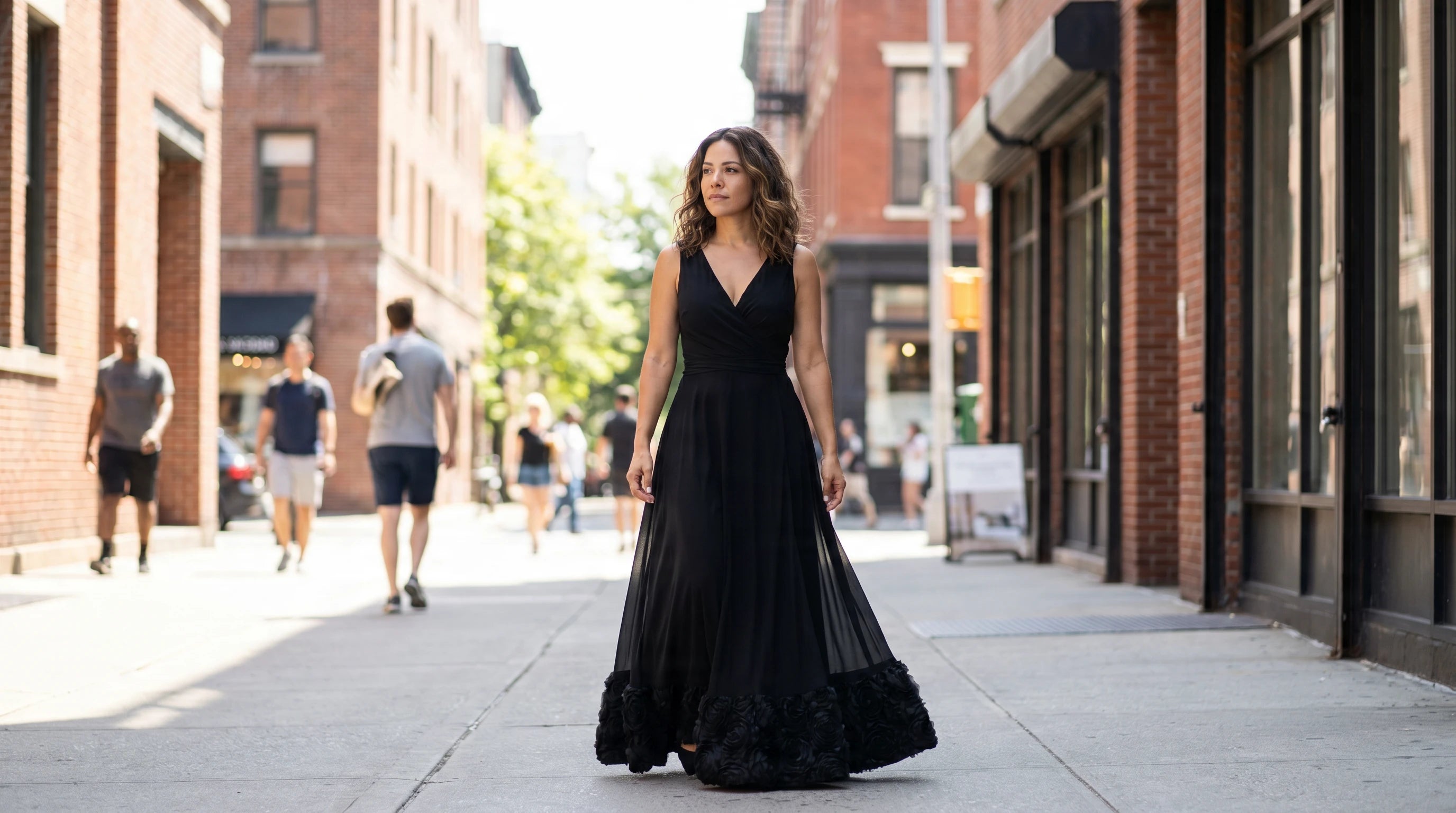 Woman in a black maxi dress walking on a city sidewalk