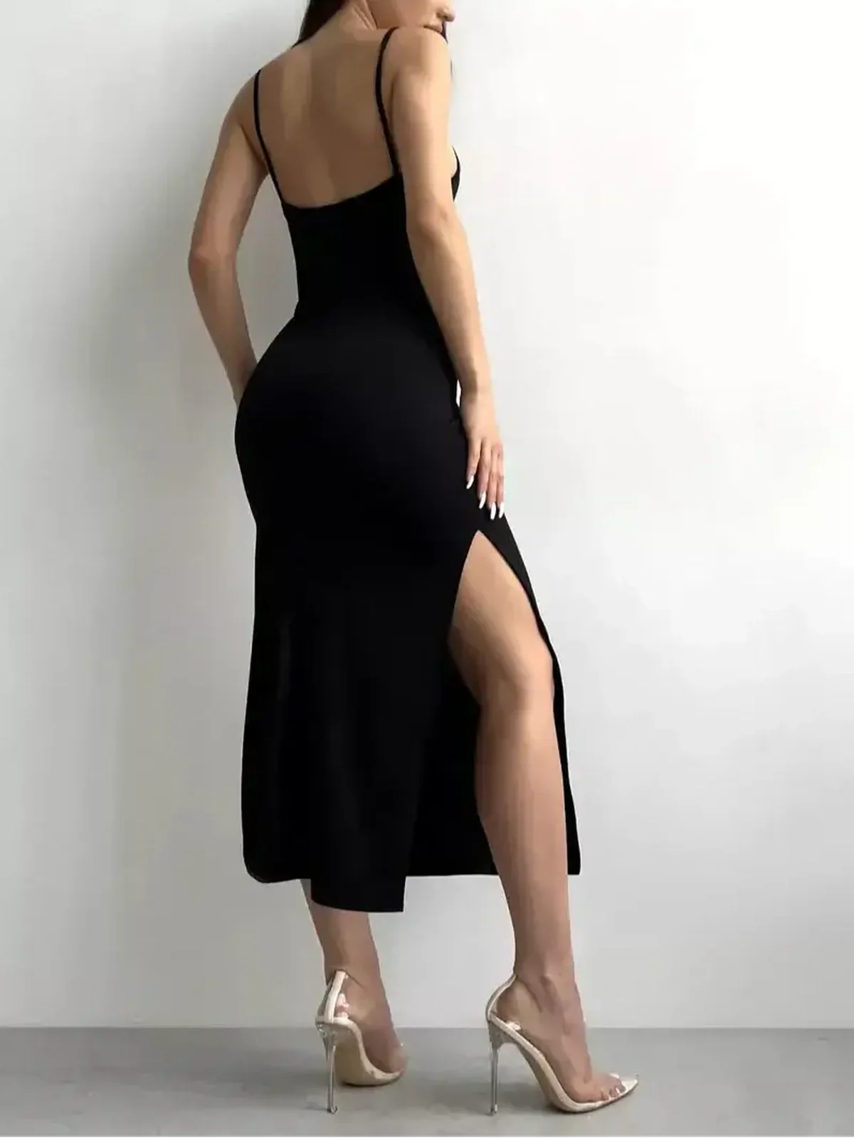 Model wearing a sleek black midi dress with a side slit, showcasing modern elegance and comfort.
