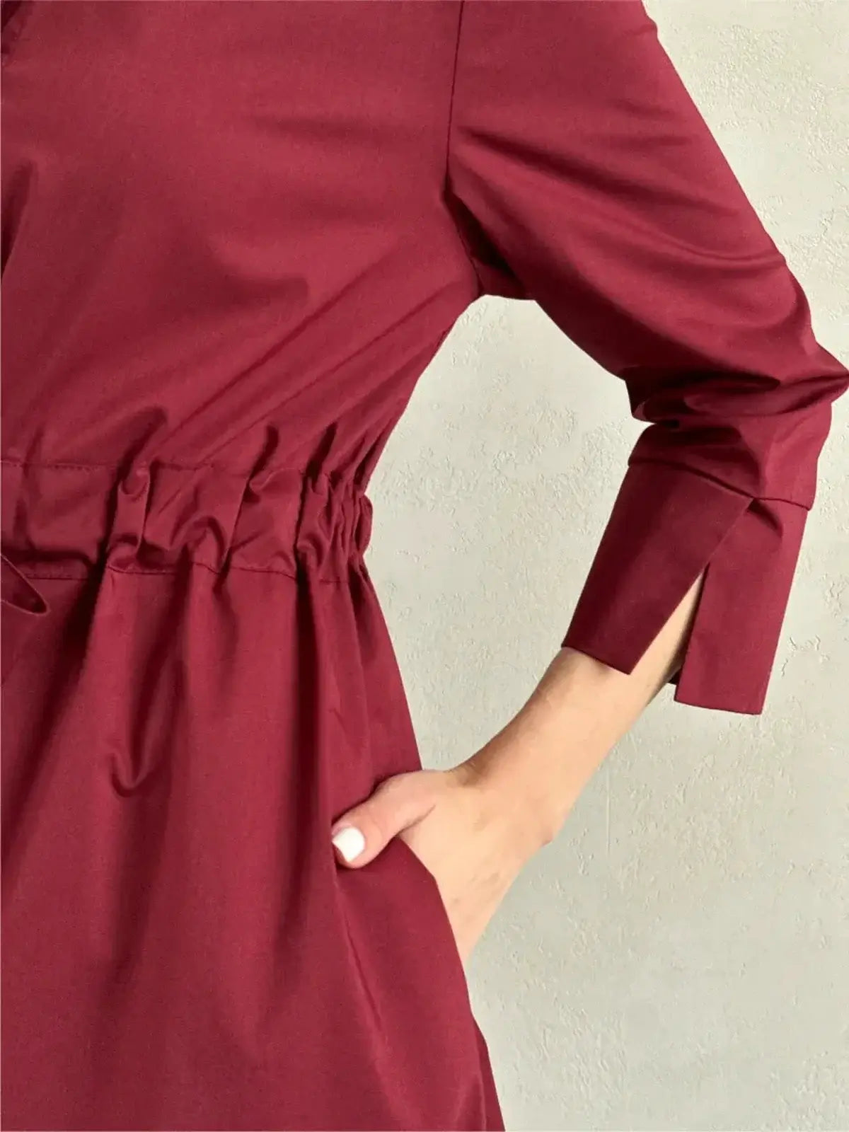 Detail of Burgundy Grace Midi Dress with cinched waist and elegant sleeve slits, perfect for wedding guest or formal occasions.