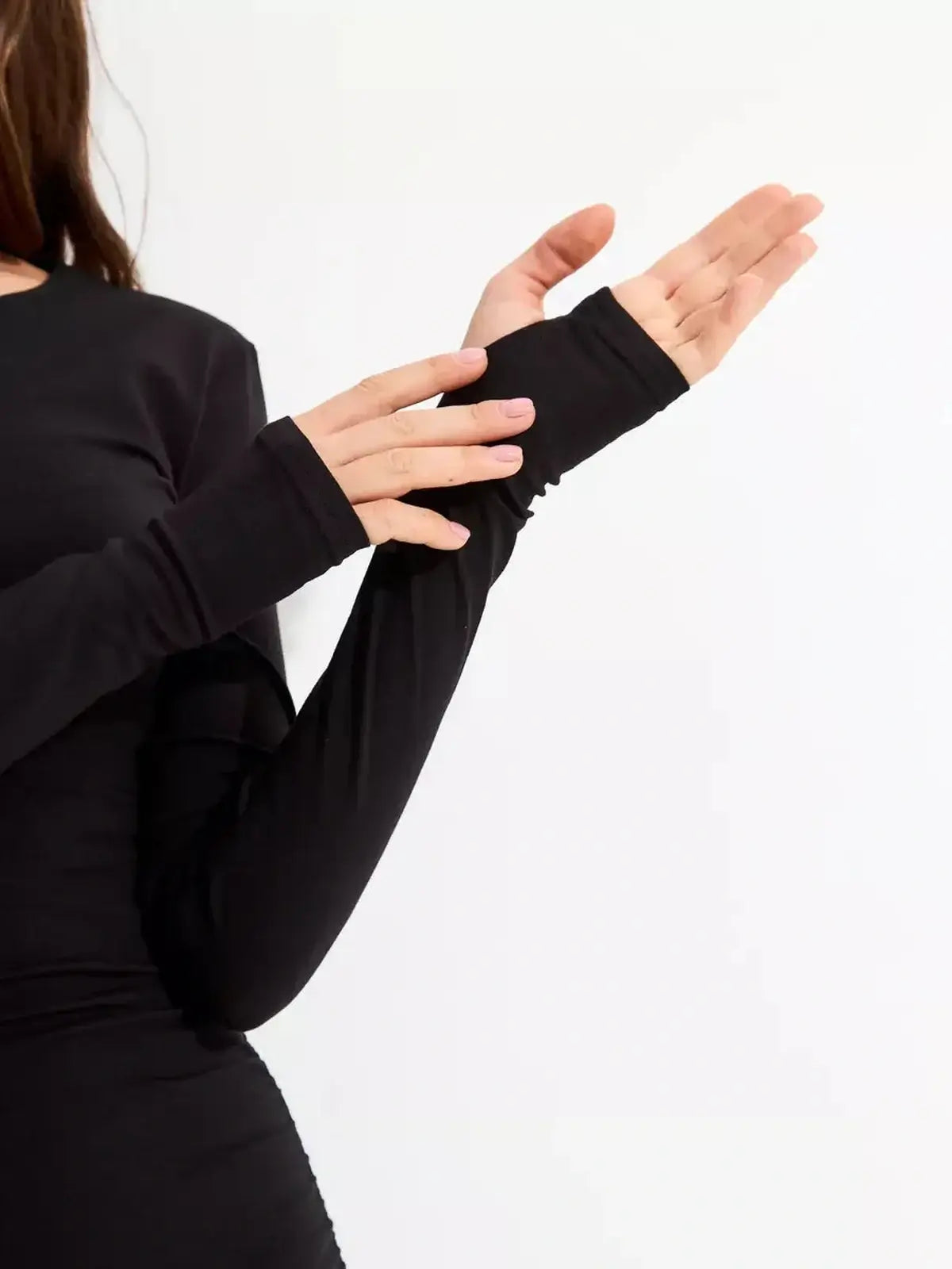 Close-up of long sleeve black dress showcasing thumbhole cuffs and soft-touch fabric detail.