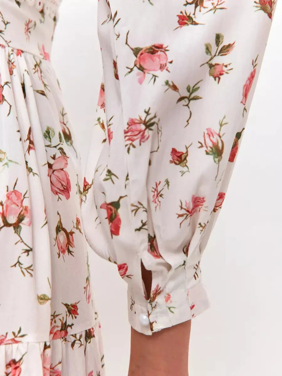 Close-up of the Rose Whimsy Mini Dress showcasing delicate rose print and lace trim on sleeves.