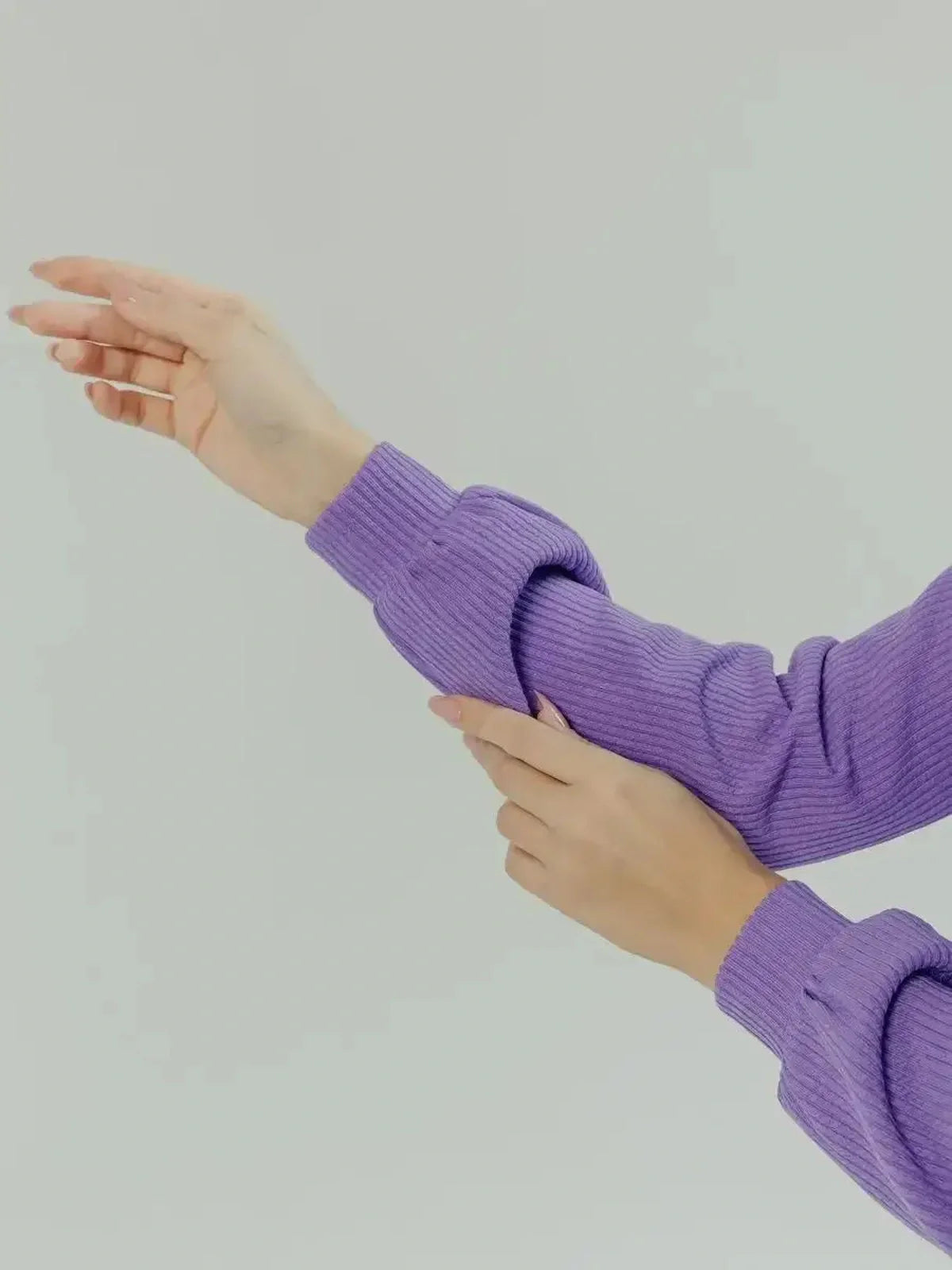Close-up of women's purple sweater sleeve showcasing stylish ribbed texture and elegant fit.