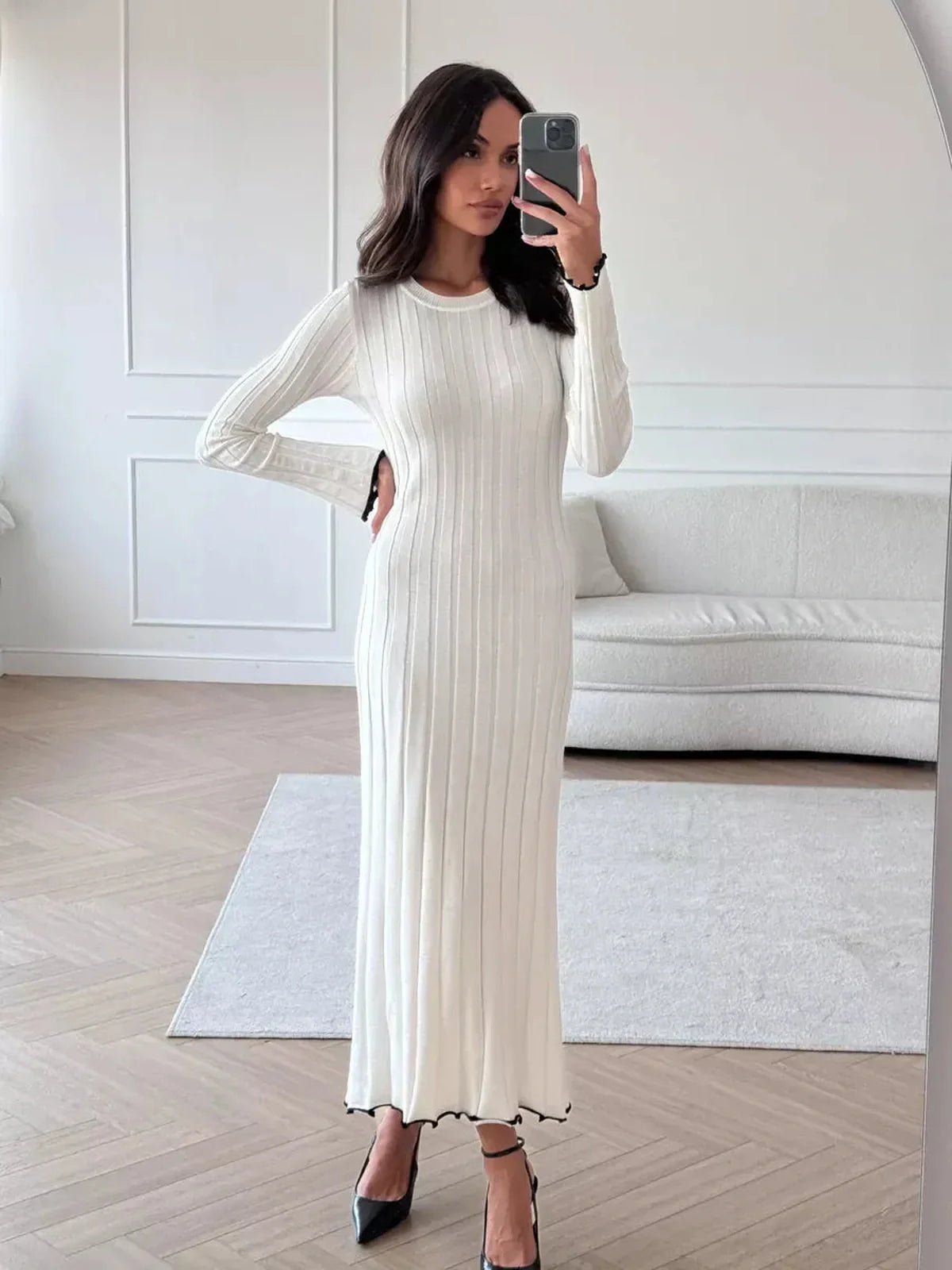 Model showcasing an Ivory Grace Maxi Dress, featuring ribbed texture and ruffle hem, perfect for weddings and formal occasions.
