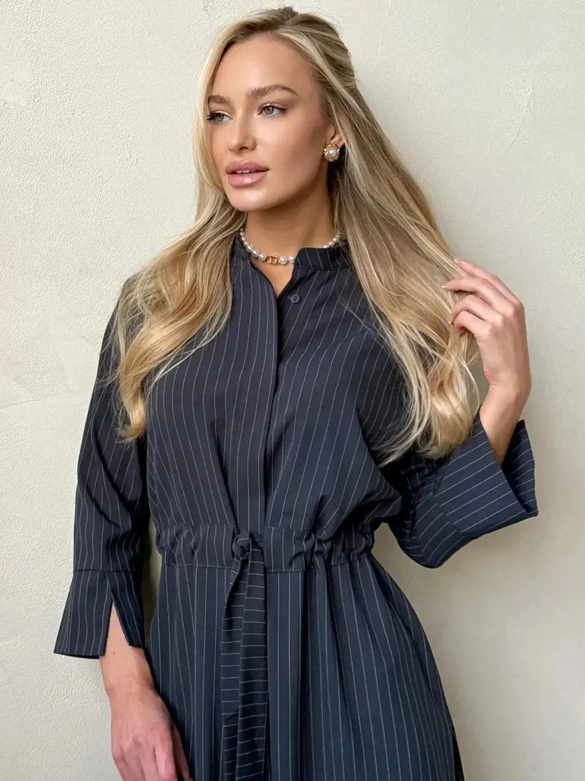 Model wearing a Slate Stripe Midi Dress with a structured silhouette and waist tie for a sophisticated look.