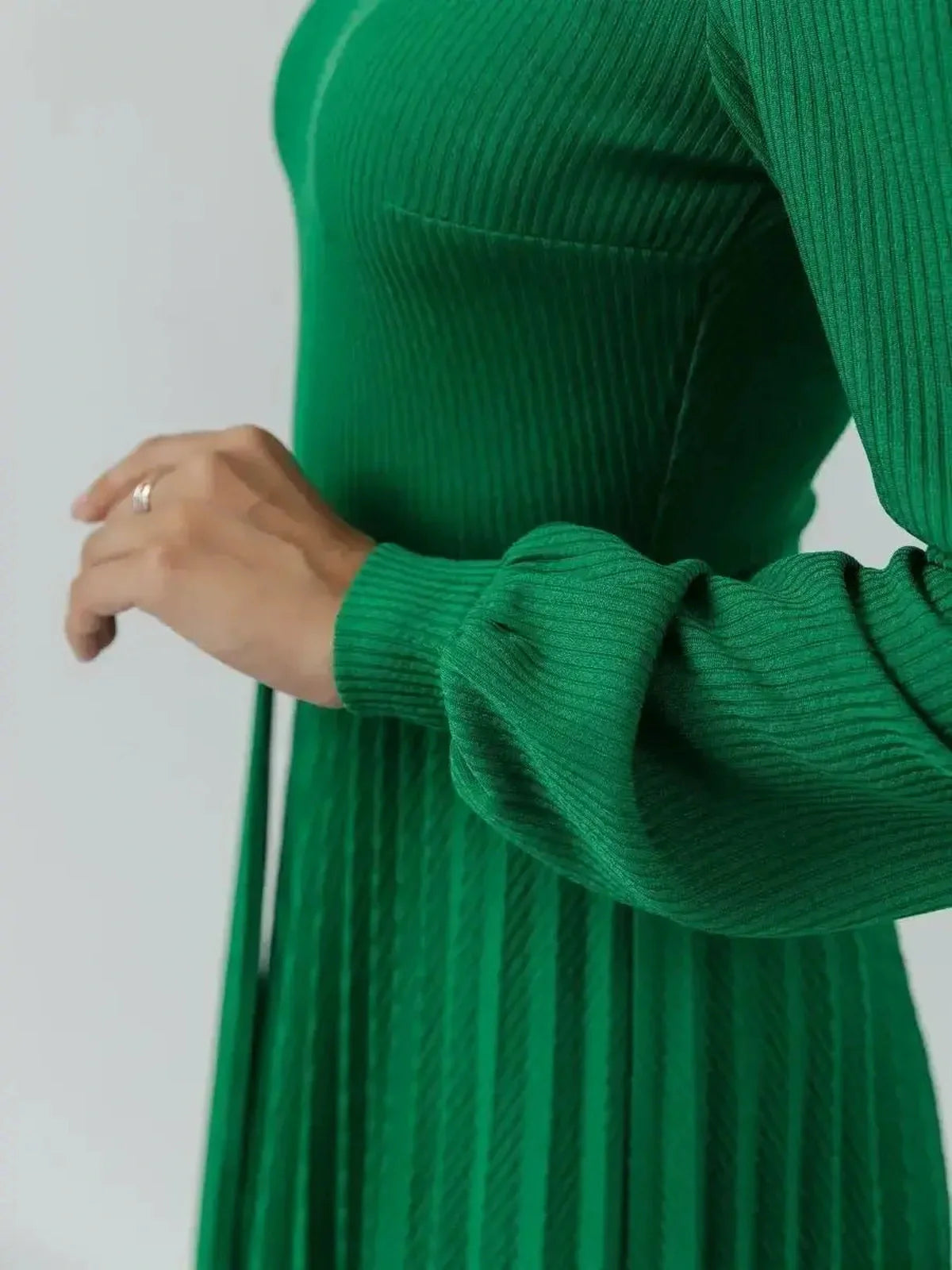Close-up of the Verde Grace Midi Dress featuring ribbed knit texture and pleated design in emerald green.