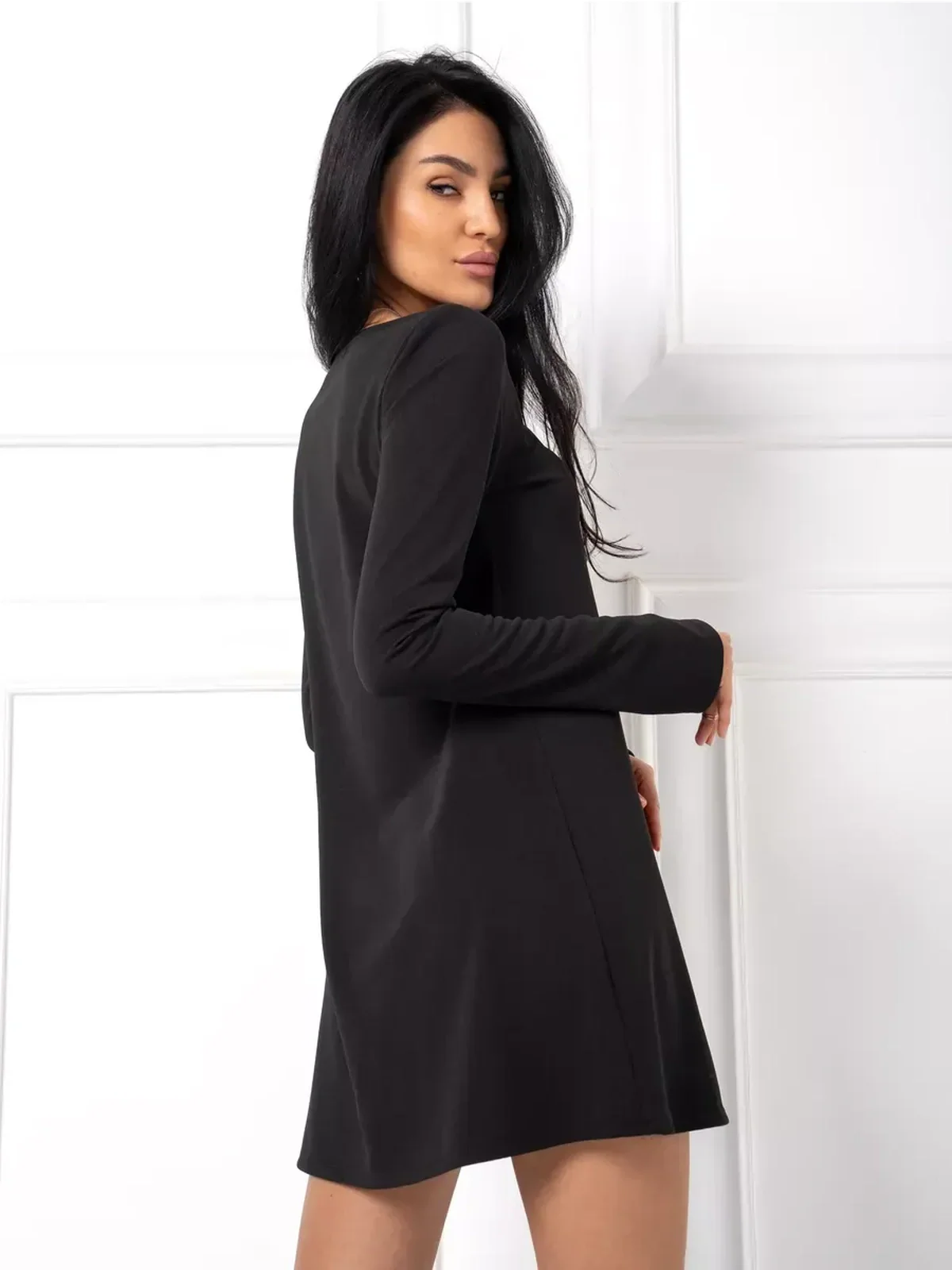 Midnight Flow black mini dress showcasing a minimalist silhouette and elegant long sleeves, perfect for weddings and casual outings.