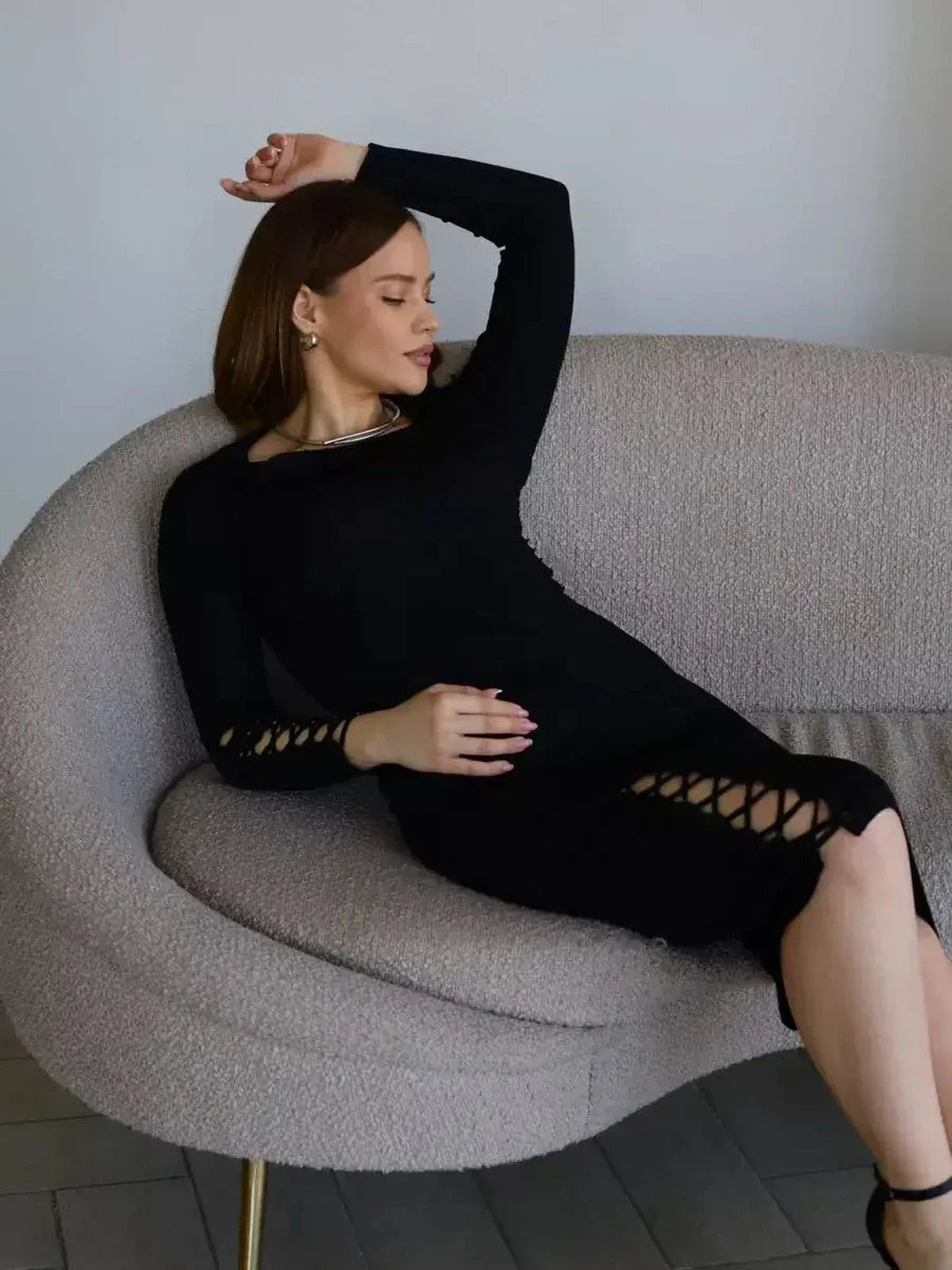 Elegantly fitted black midi dress with lace-up accents, perfect for chic soirées and elevated evening wear.