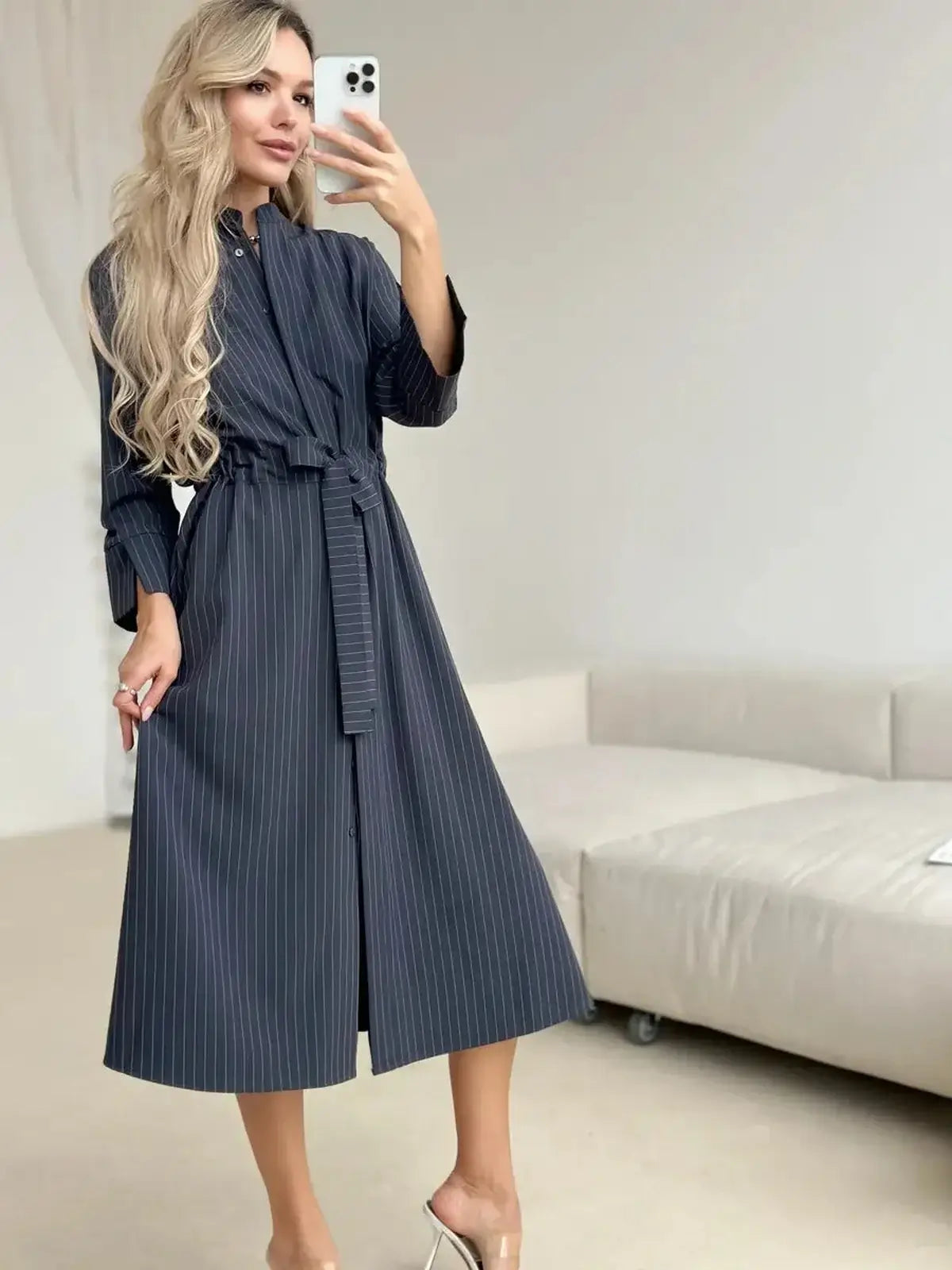 Stylish woman in a slate stripe midi dress showcasing tailored elegance with a relaxed fit and soft waist tie.