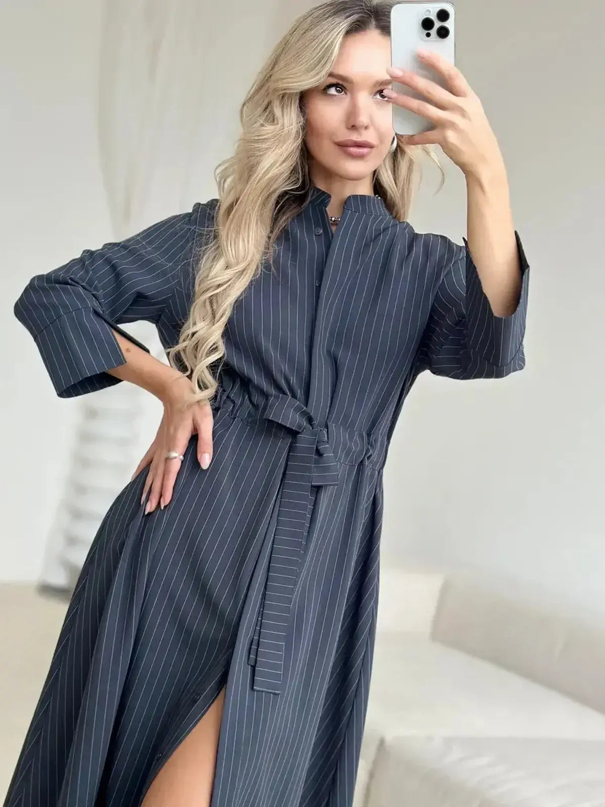 Model showcasing a Slate Stripe Midi Dress with vertical pinstripes and a waist tie, perfect for versatile occasions.