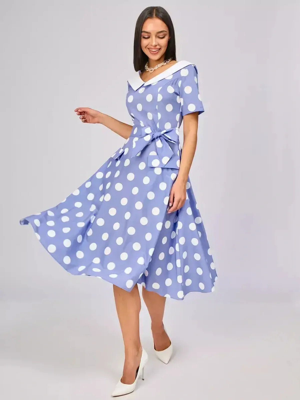 Sky-blue midi dress with white polka dots, flattering fit-and-flare silhouette, and a chic collar, perfect for summer events.