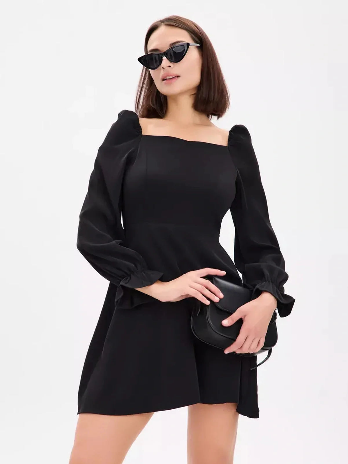 Model wearing the Midnight Frame Mini Dress featuring clean lines and structured puffed sleeves in black.