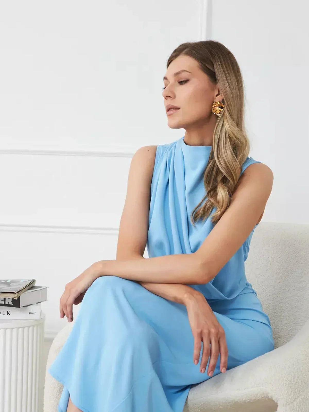 Model showcasing the Sculpted Grace Maxi Dress in blue, featuring a sleek, draped silhouette ideal for formal occasions.