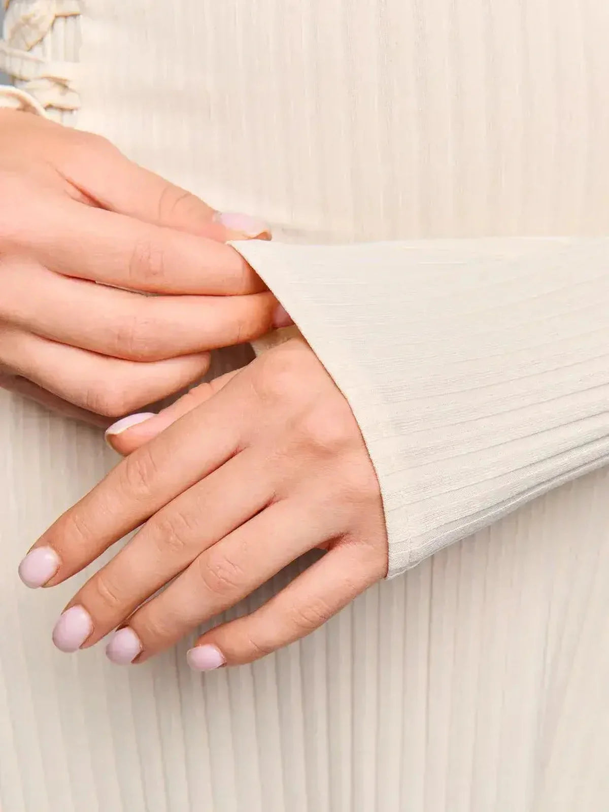 Close-up of hands showcasing the soft ribbed texture and long sleeve of the Ribbed Charm Midi Dress.