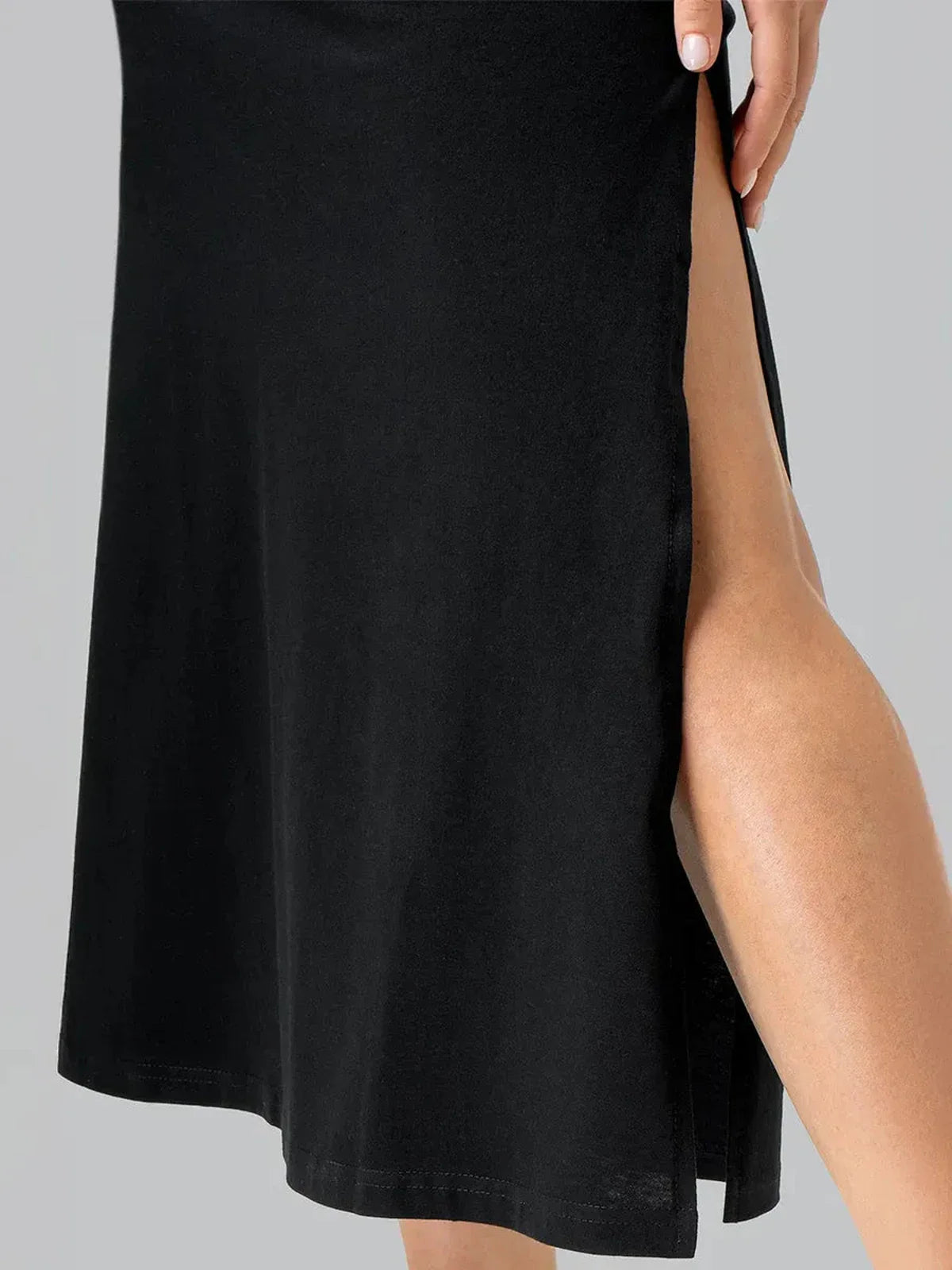 Close-up of a black midi dress featuring a thigh-high side slit, showcasing its sleek design and breathable fabric.