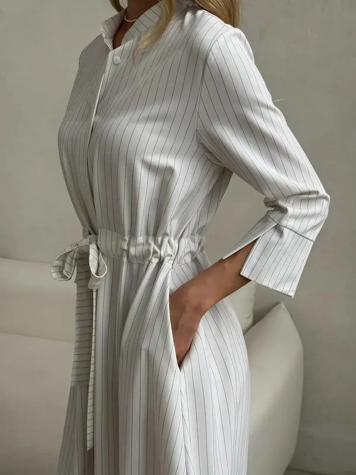 Elegant pinstripe midi dress with waist tie, perfect for business casual or weekend brunches.