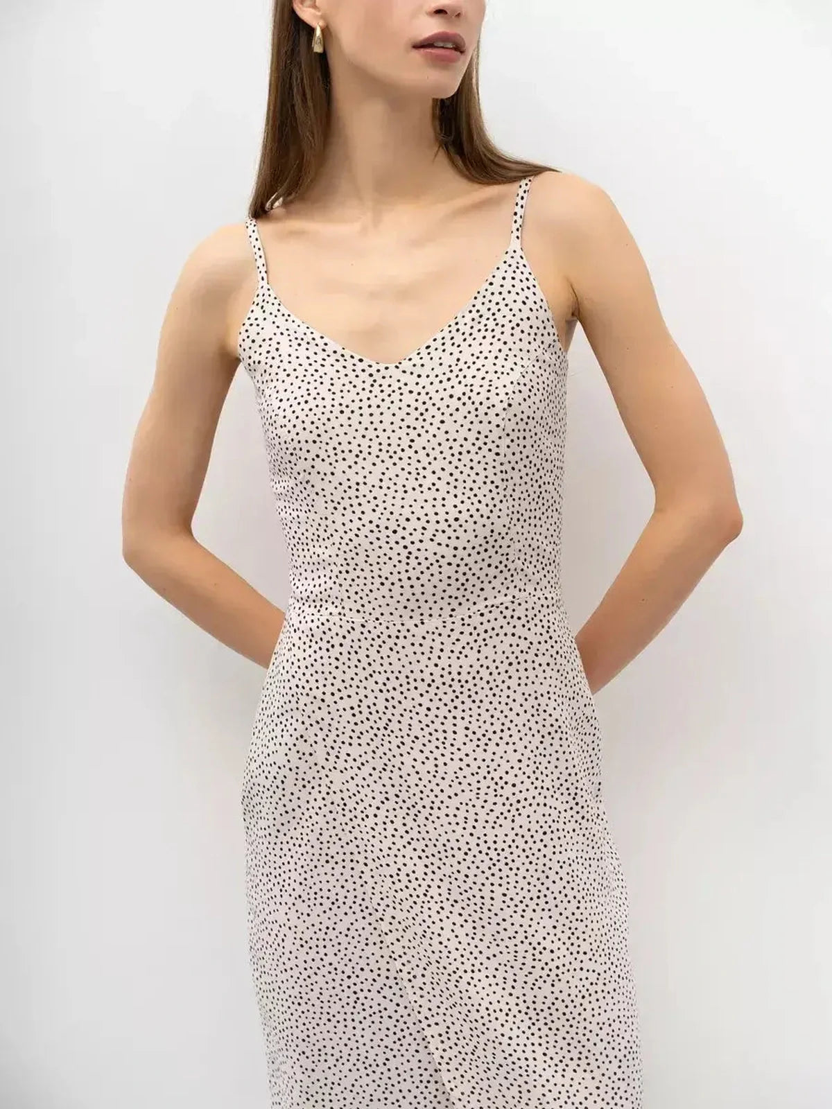 Model wearing a playful Dot Whisper Midi Dress featuring a V-neckline and polka dot print, perfect for summer and wedding guest attire.