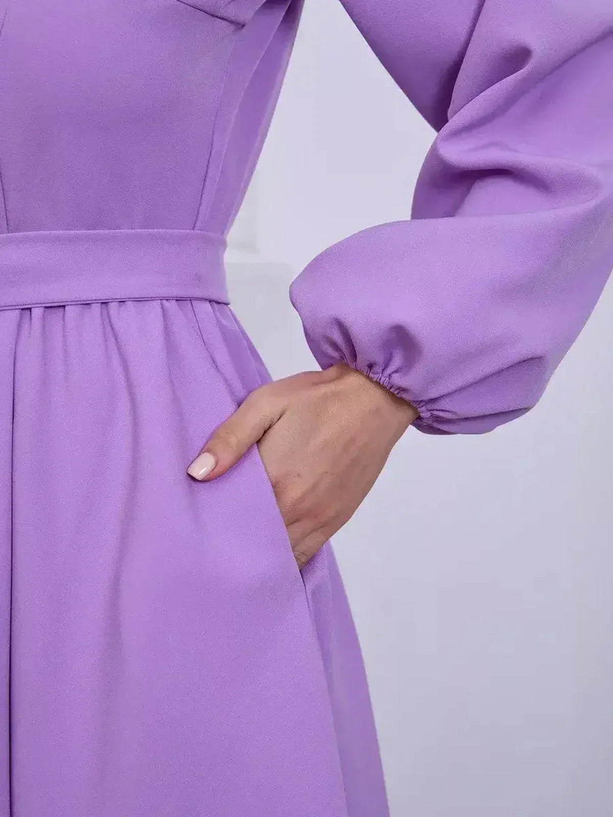 Close-up of a lilac long sleeve dress featuring a fitted bodice and cinched waist, perfect for wedding guest or prom occasions.