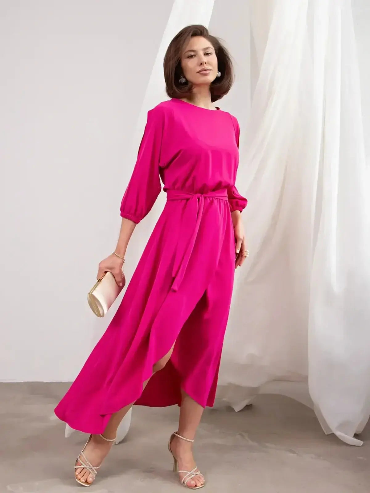 Model wearing a striking fuchsia Twilight Bloom Midi Dress with shoulder cutouts and a flattering high-low hemline.