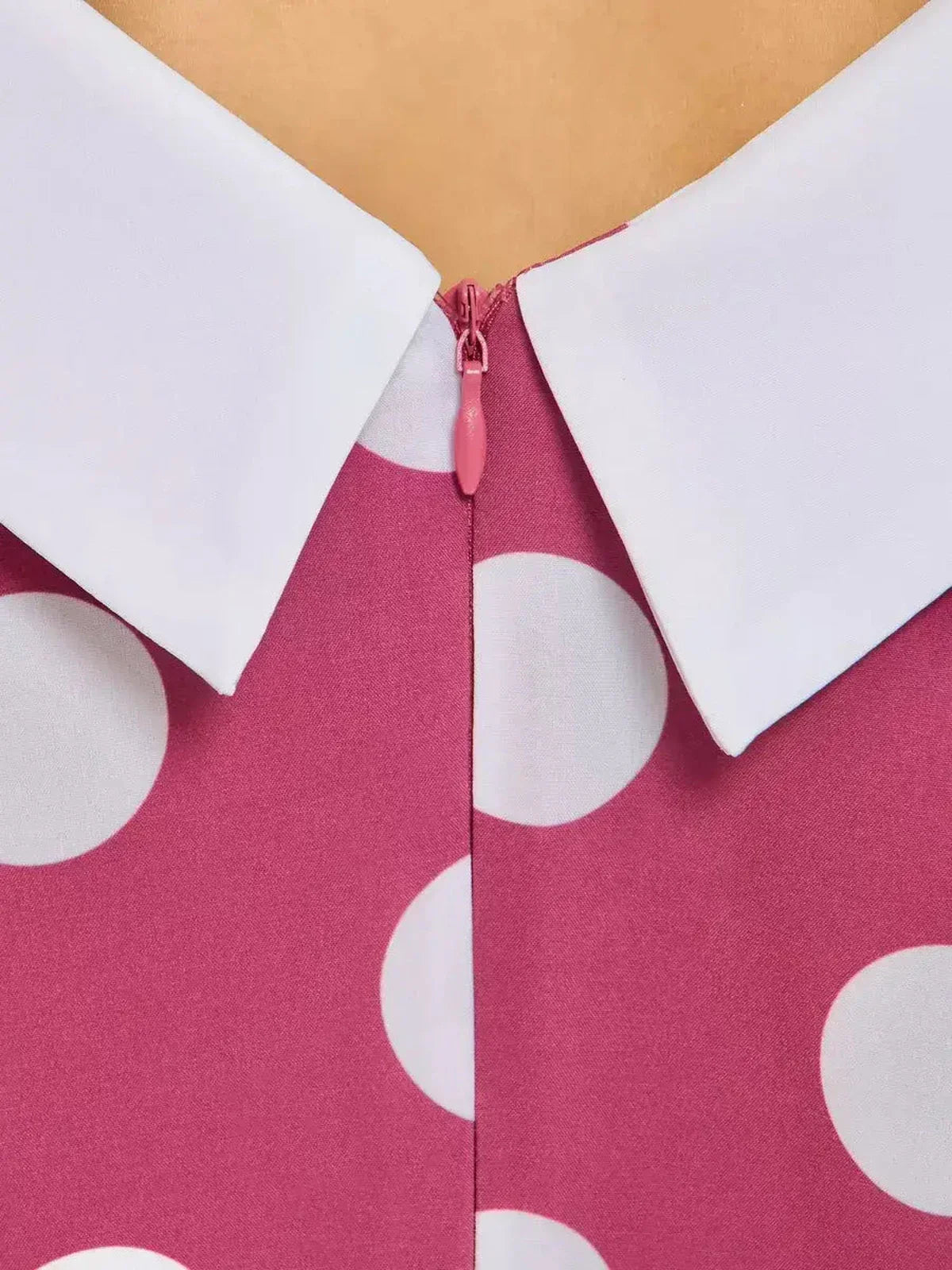 Close-up of the Retro Dot Midi Dress featuring a white collar and pink fabric with large white polka dots.