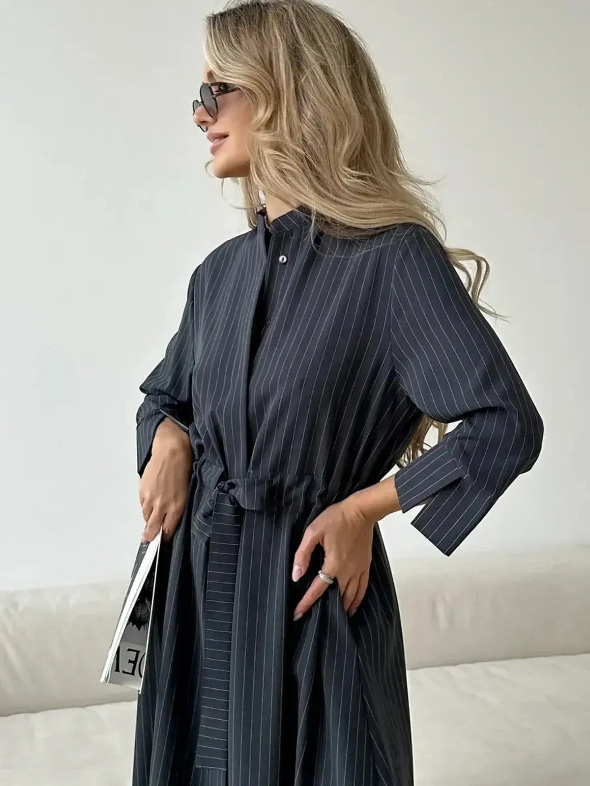 Model showcasing a stylish Slate Stripe Midi Dress with a relaxed fit and vertical pinstripes, perfect for various occasions.