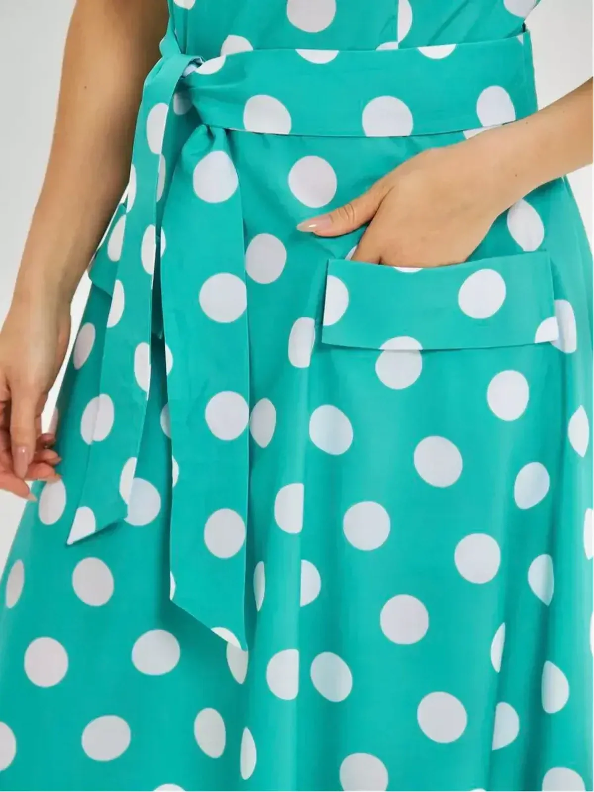 Polka Grace Midi Dress detail showcasing turquoise fabric with white polka dots, tie waist, and side pocket.