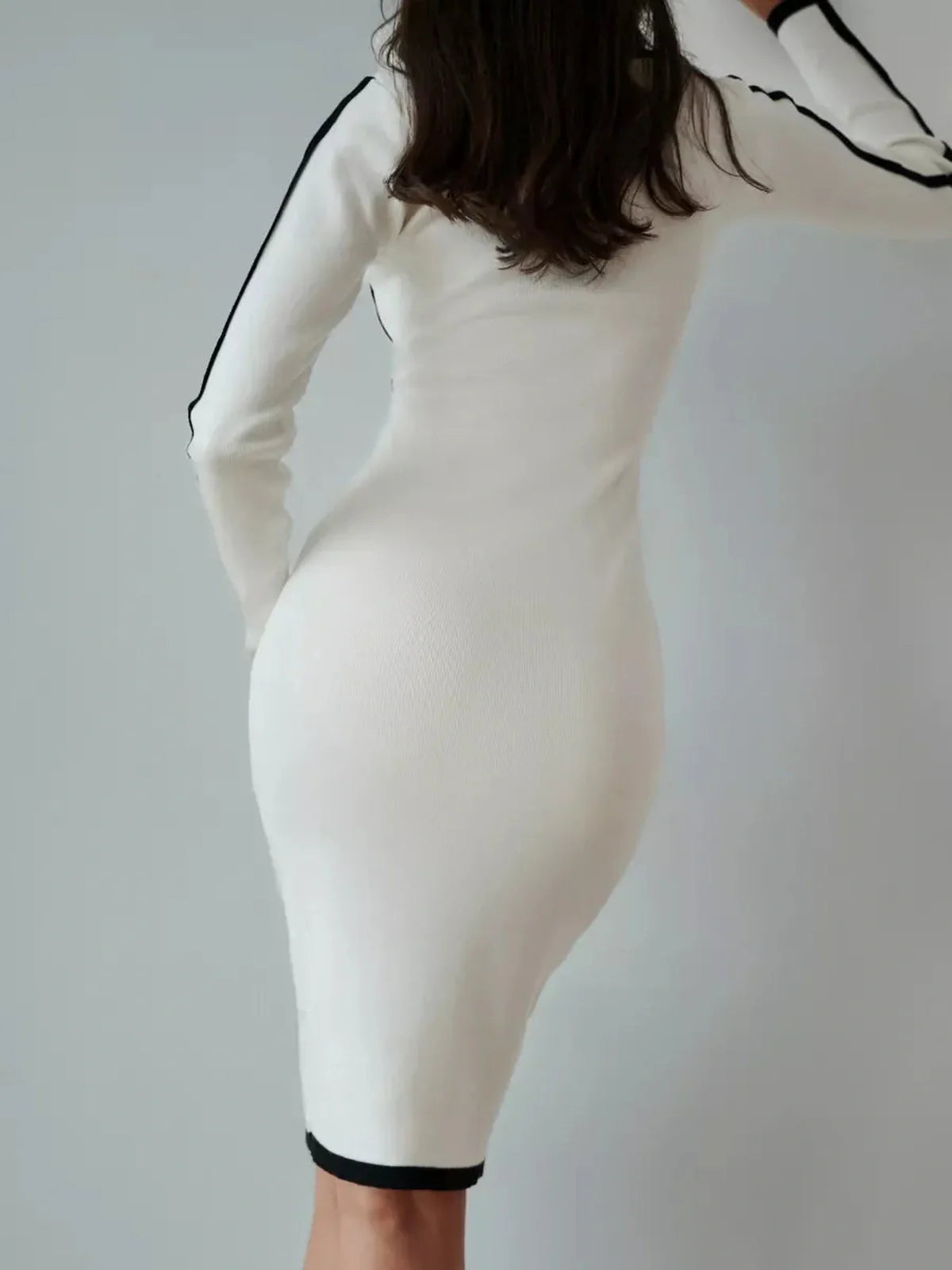 Back view of a Framed Elegance Midi Dress in white with black piping, showcasing a form-fitting, sophisticated silhouette.