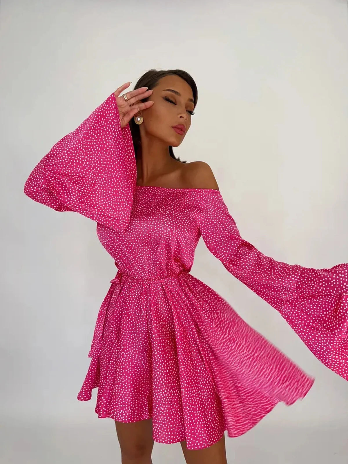 Flirt Pulse Mini Dress in bold pink with white polka dots, featuring off-the-shoulder style and flared sleeves.