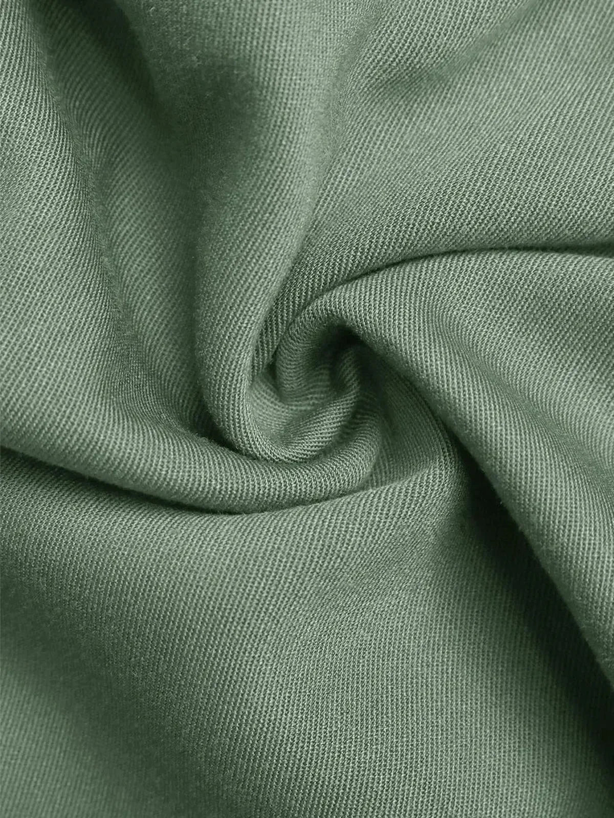 Close-up of soft green viscose fabric showcasing its texture, ideal for summer dresses.