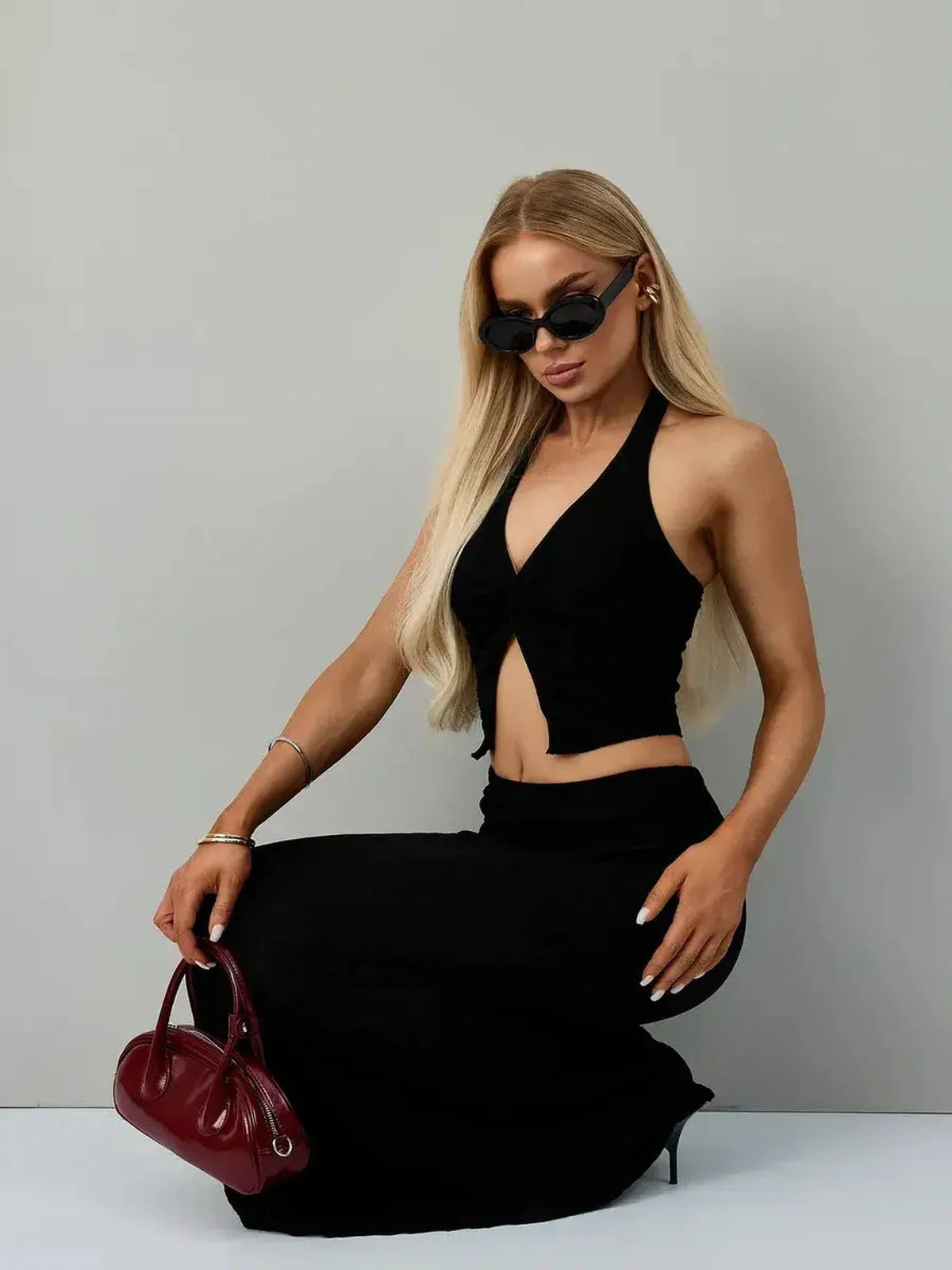 Model showcasing the Noir Edge Set, a stylish black halter top and maxi skirt, perfect for formal occasions.