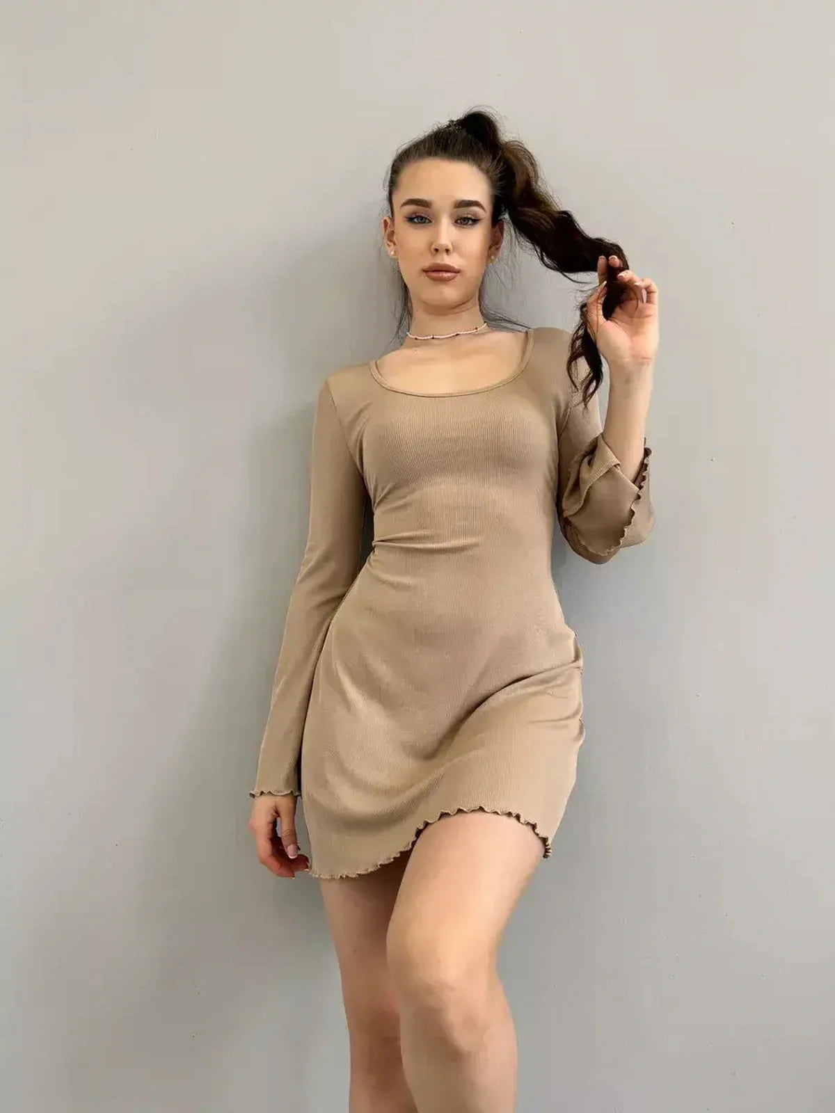 Sahara Glow neutral-tone mini dress featuring long sleeves, squared neckline, and delicate ruffled hem, ideal for various occasions.