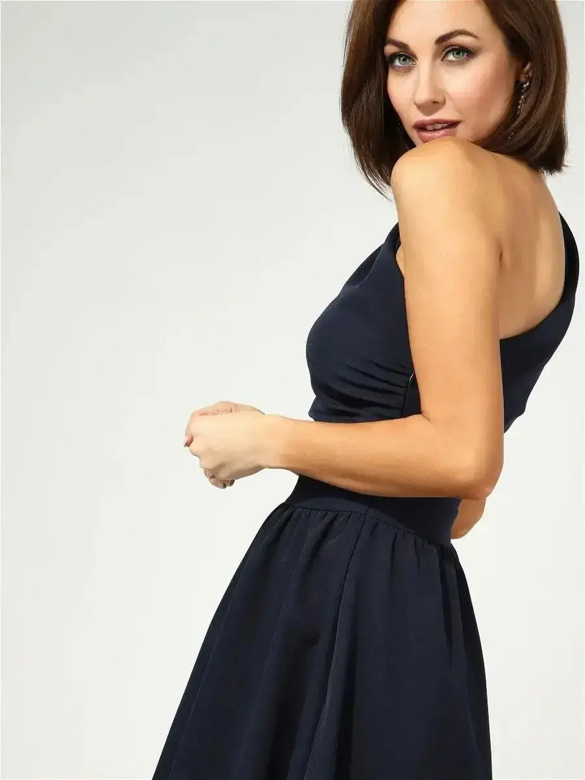 Model showcasing the Sculpted Grace Midi Dress in dark navy, featuring a one-shoulder design and flared silhouette.