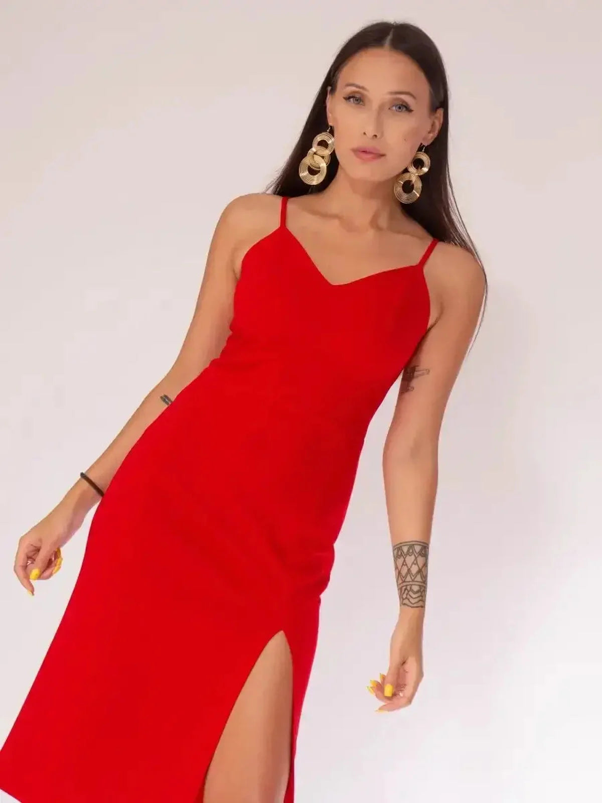 Stylish woman in a red midi dress with a front slit, perfect for cocktail or formal events.