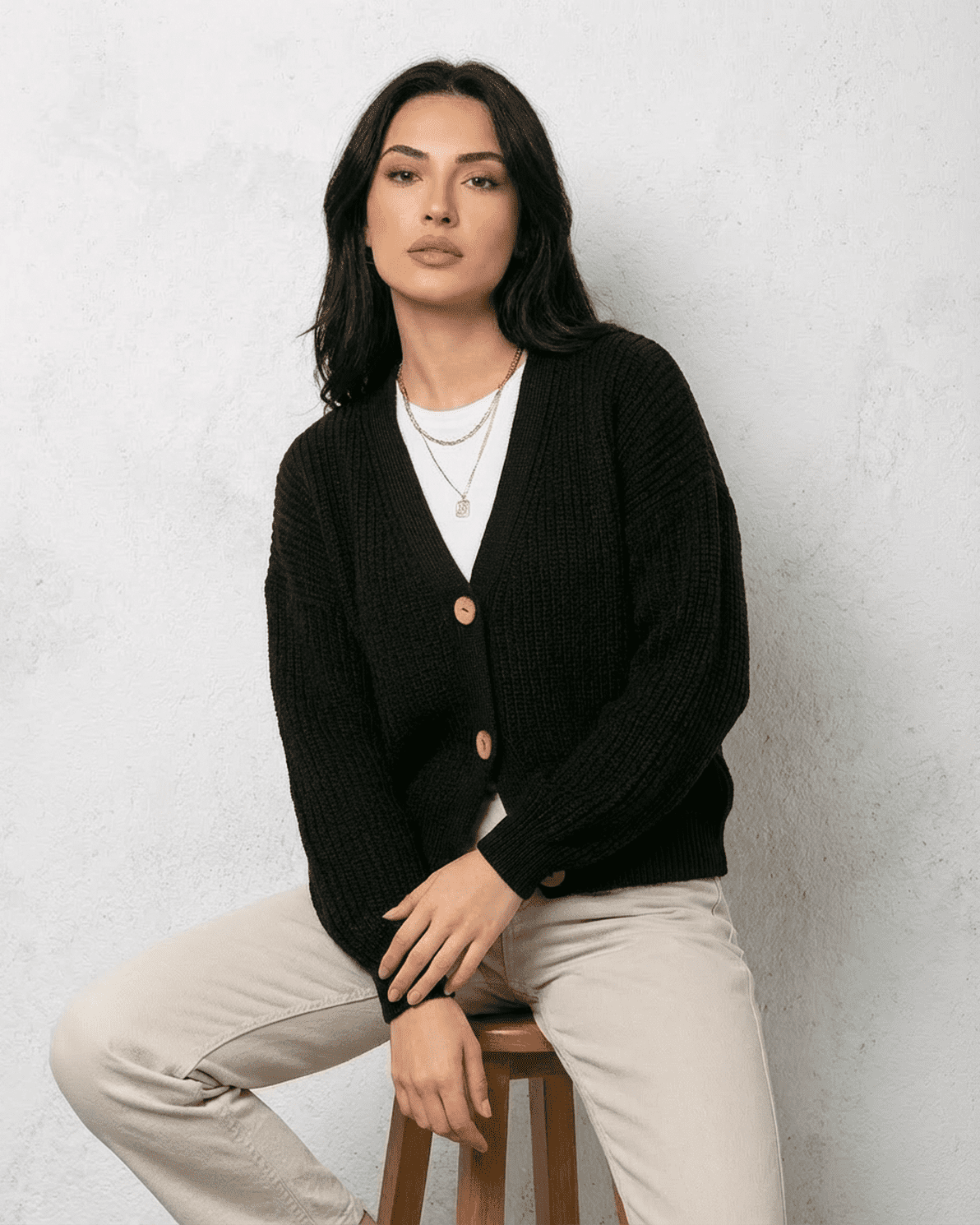 Noir Cardigan by Slimona, a sleek black knitwear piece featuring a classic V-neck and button detail.