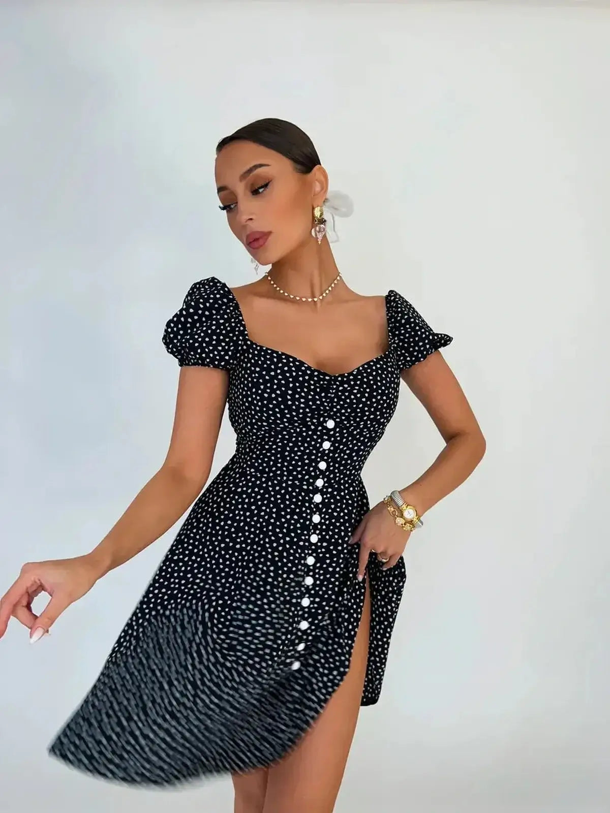 Woman wearing a classic Noir Chic Mini Dress with polka dots and a sweetheart neckline.