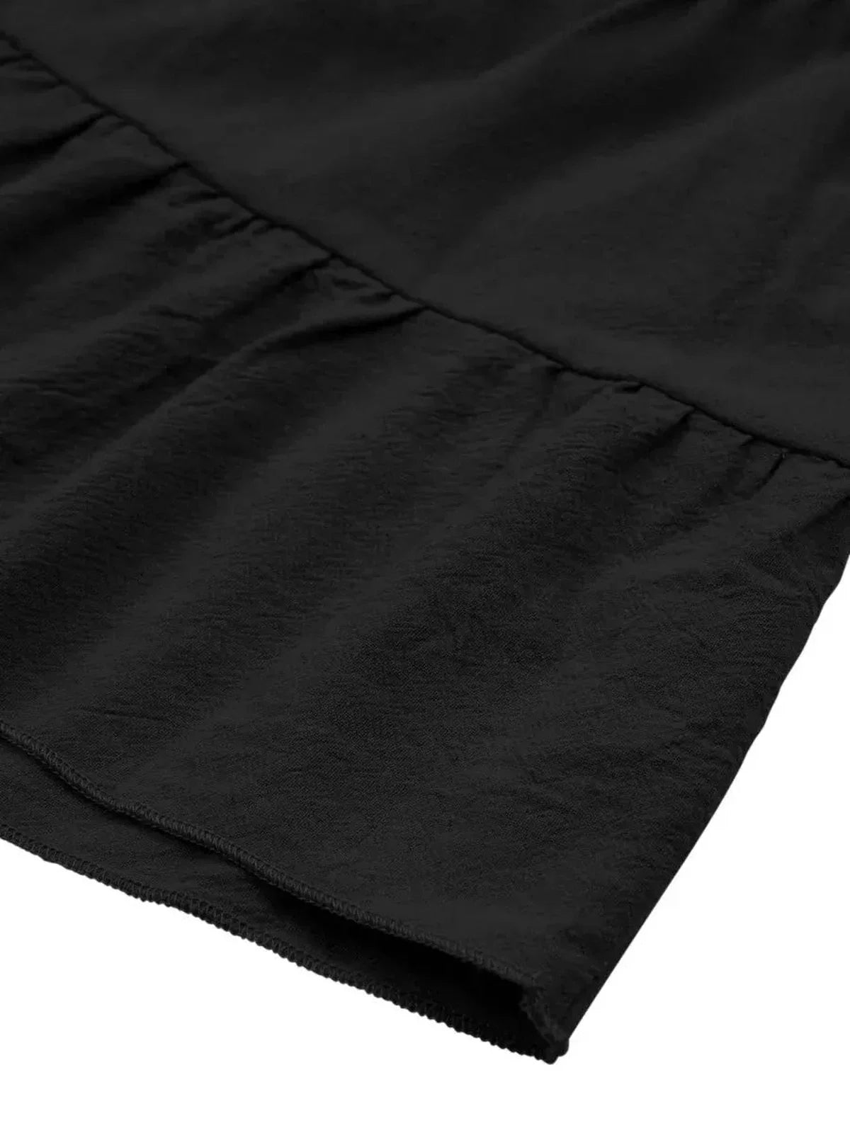 Close-up of the Noir Whirl Mini Dress showcasing the tiered A-line skirt in elegant black fabric.