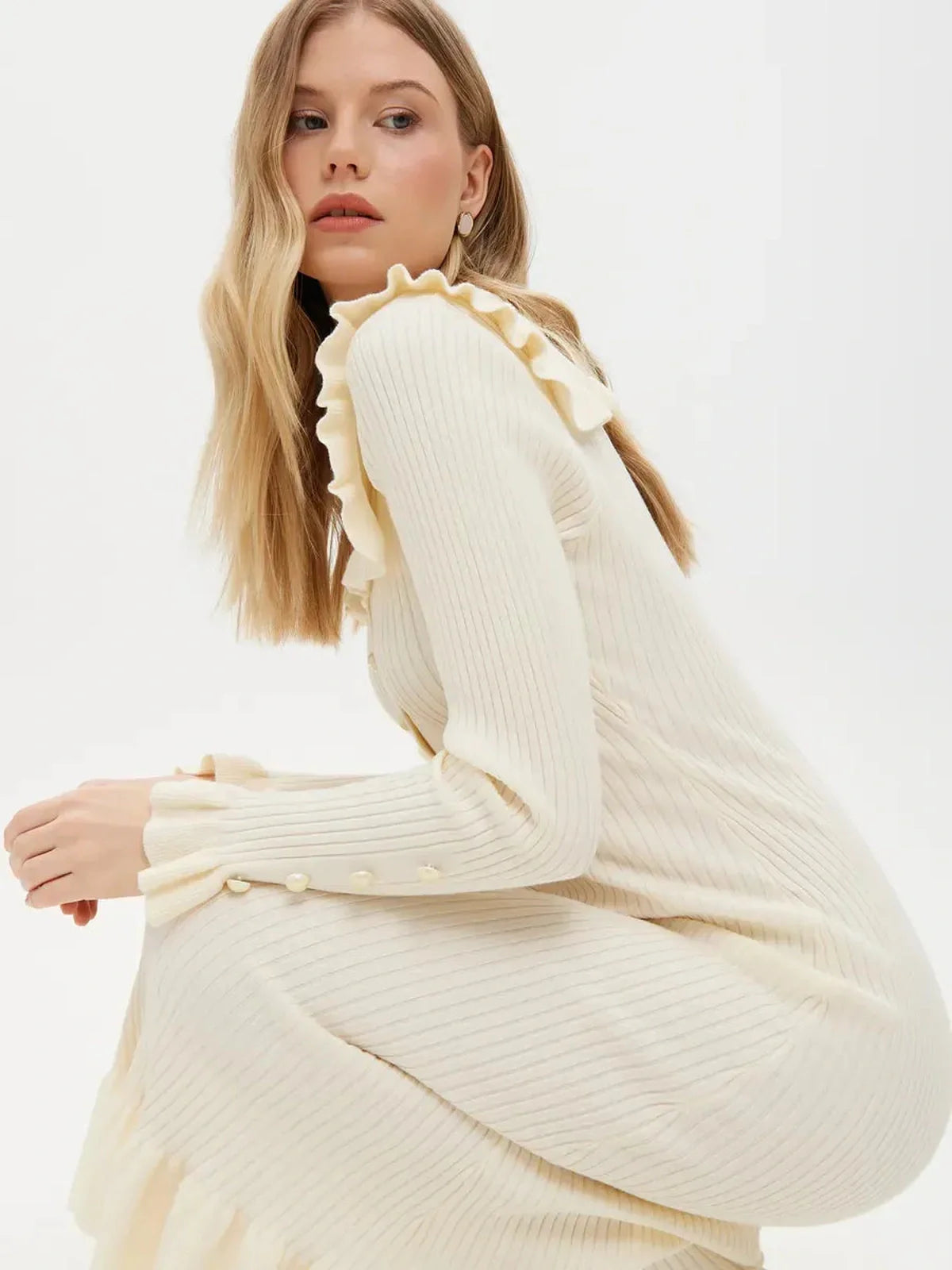 Model wearing an elegant Pearl Ruffle Midi Dress featuring a soft rib-knit and romantic flounce collar.
