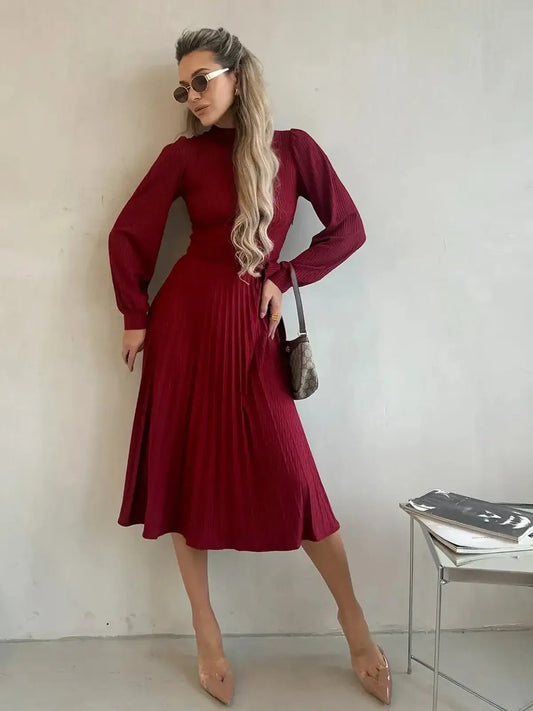 Model wearing a crimson midi dress with pleats, showcasing timeless elegance for formal occasions.