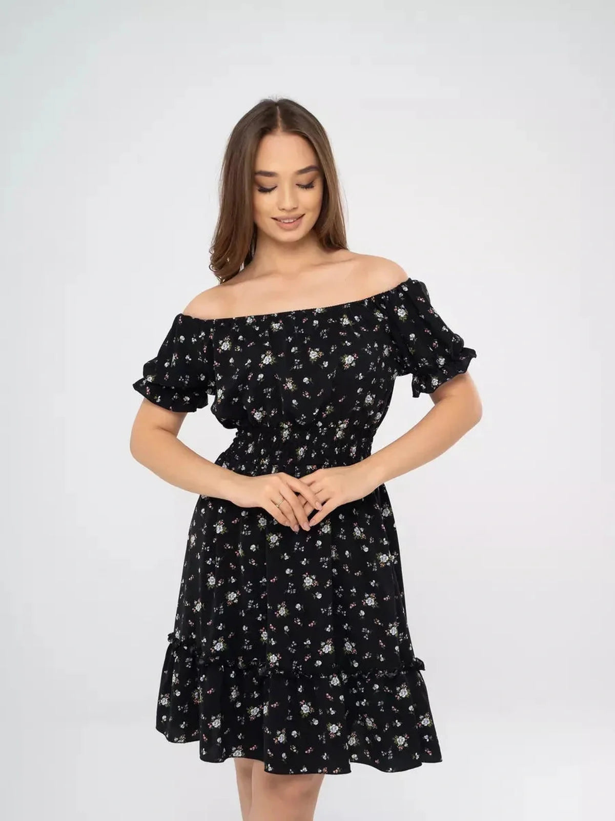 Woman modeling a stylish black floral dress with off-shoulder neckline, perfect for summer events and casual outings.