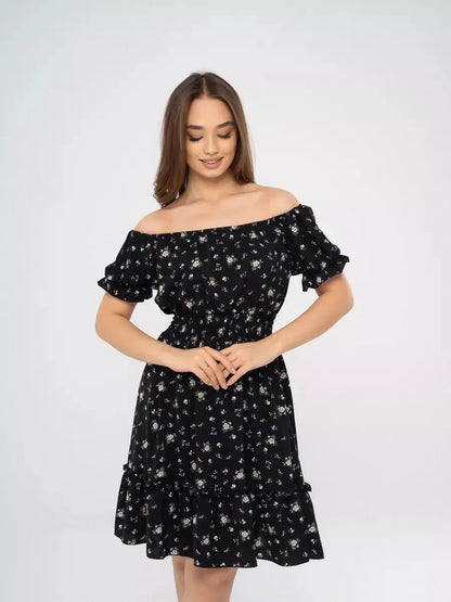 Woman modeling a stylish black floral dress with off-shoulder neckline, perfect for summer events and casual outings.