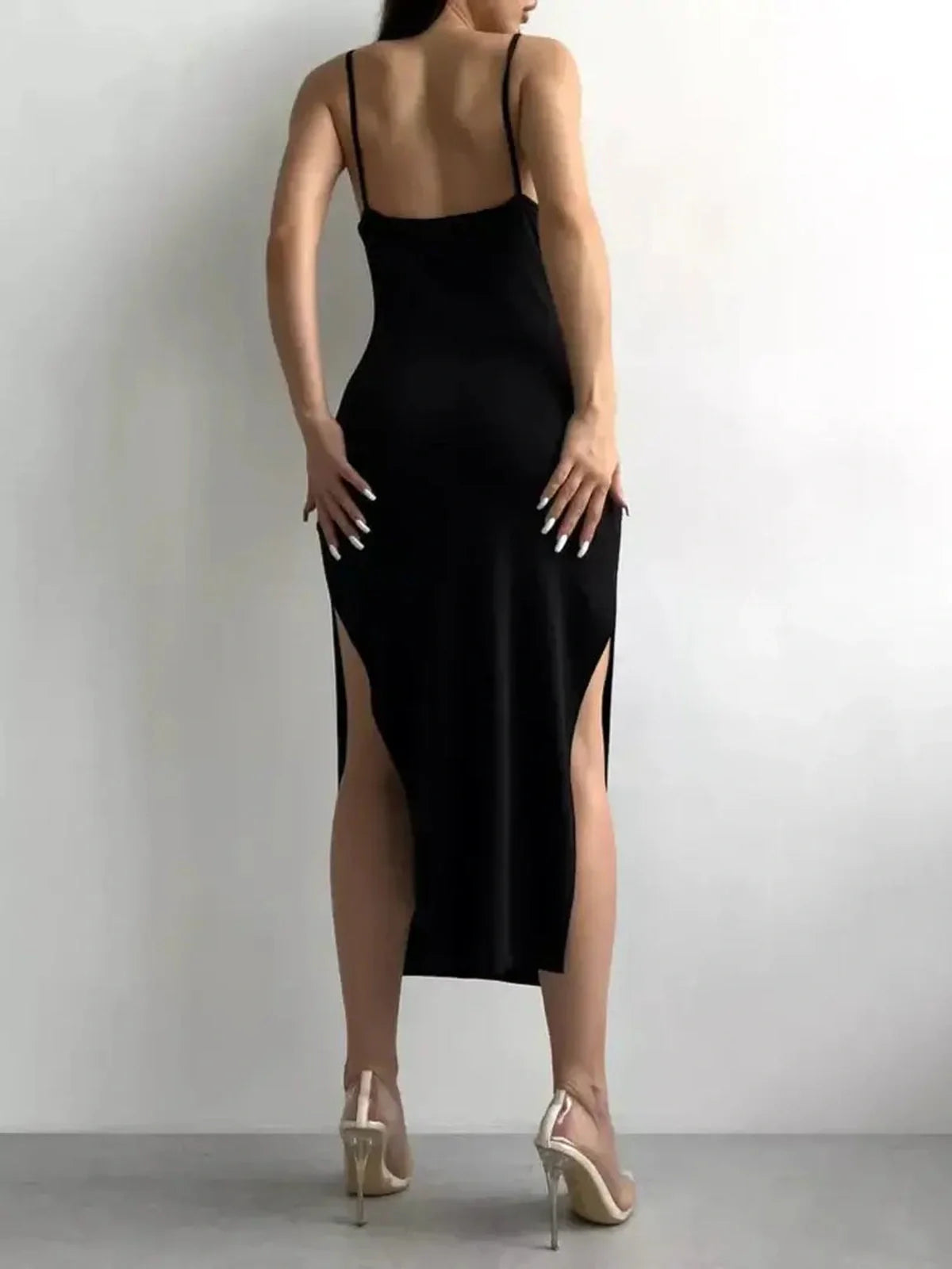 Back view of a sleek black midi dress with a sculpted silhouette and high slits, perfect for formal or cocktail occasions.