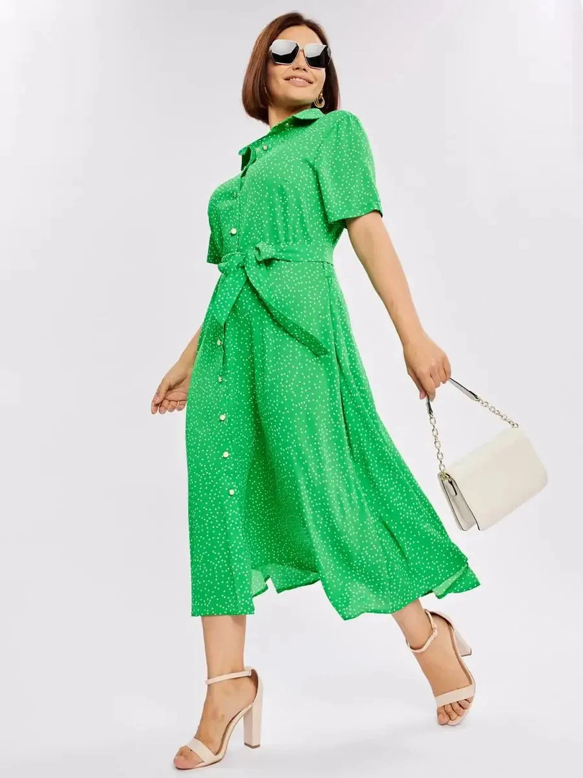 Model showcasing a vibrant green Garden Dot Midi Dress with white dots, ideal for summer and casual outings.