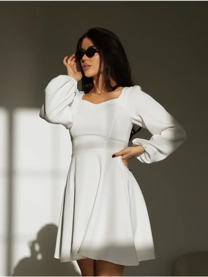 Elegant white dress featuring a sweetheart neckline and puffy sleeves, perfect for weddings and formal occasions.