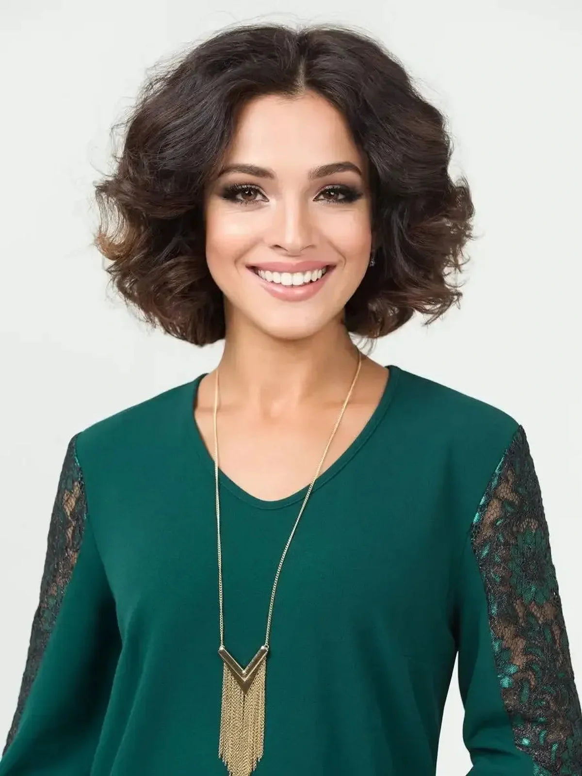 Elegant woman smiling in a green dress with lace detailing, showcasing stylish women's fashion.