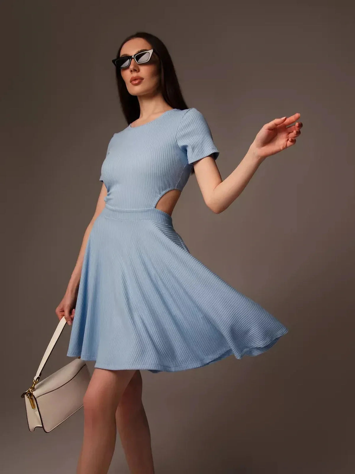 Model wearing a light blue mini dress with a cut-out waist, perfect for summer occasions and bridal events.
