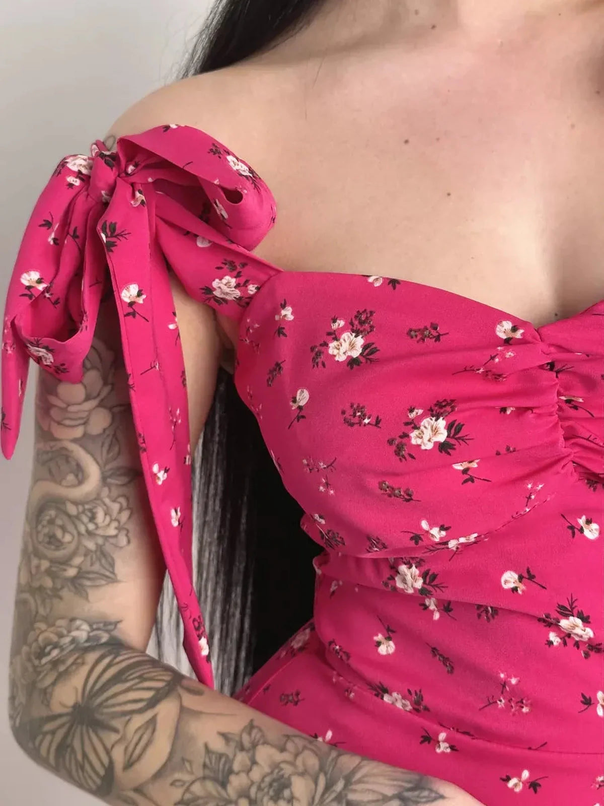 Close-up of the Rosé Charm Midi Dress showcasing pink floral print and adjustable tie shoulder detail.