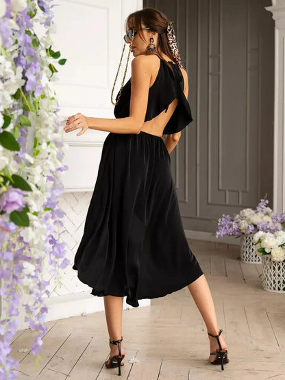 Elegant black Soirée Midi Dress with open back and flowing A-line silhouette, perfect for summer weddings or formal events.