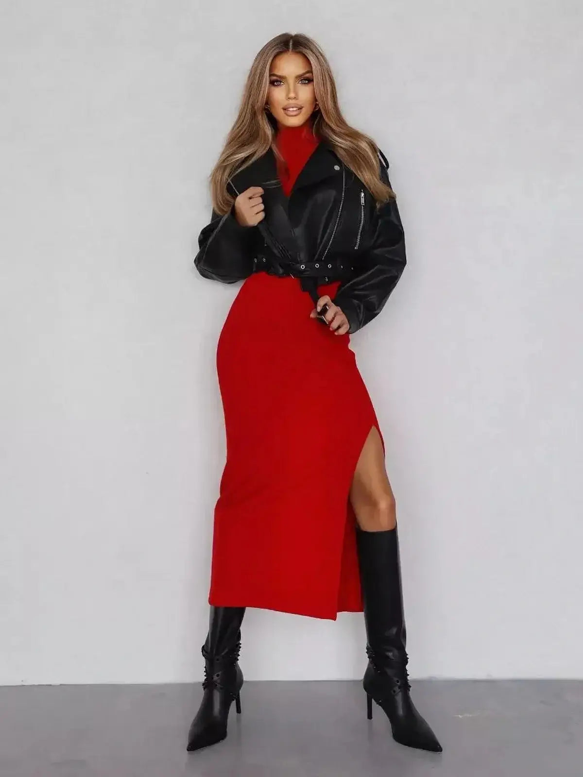 Sculpted Midi Dress in red with thigh-high slit, paired with a leather jacket and knee-high boots, ideal for formal occasions.