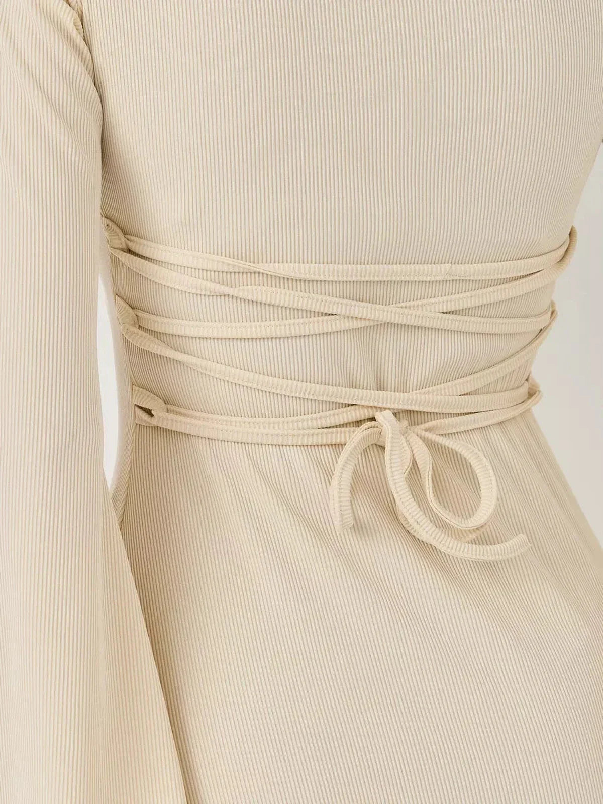 Close-up of the back detail of the Ivory Flare mini dress showcasing the lace-up design and ribbed texture.
