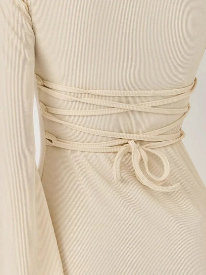 Close-up of the back detail of the Ivory Flare mini dress showcasing the lace-up design and ribbed texture.
