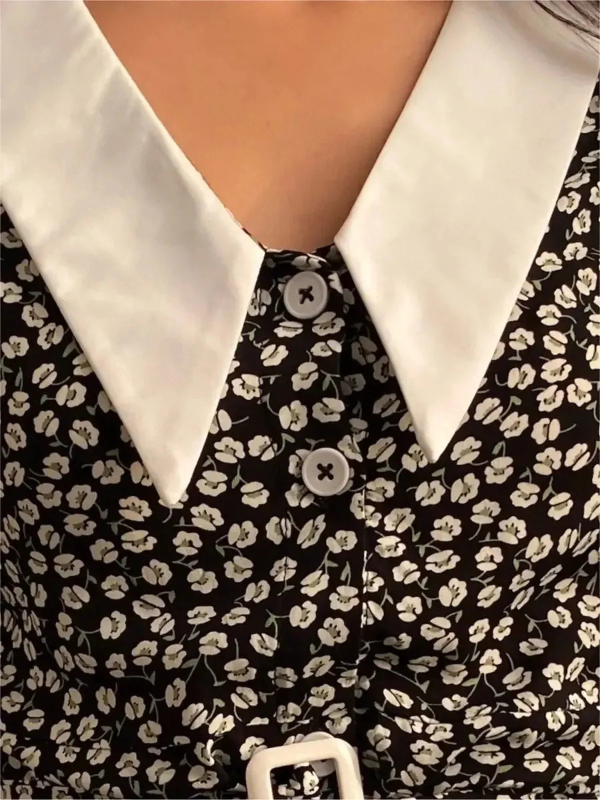 Close-up of Vintage Charm Mini Dress featuring floral print, white collar, and button details for a chic summer look.